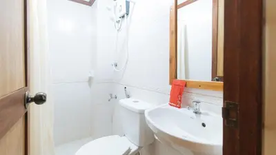 a bathroom with a toilet and a sink and a mirror at RedDoorz at Moonwalk Paranaque in Manila