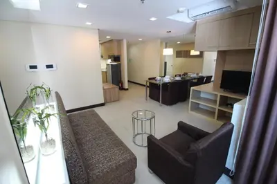 a living room with a couch and a dining room at BSA Twin Towers in Manila