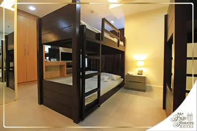a bunk bed in a room with a bed in a room at BSA Twin Towers in Manila