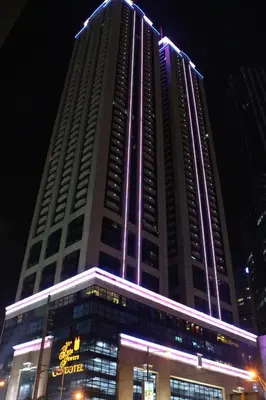 a tall building with lights on it at night at BSA Twin Towers in Manila