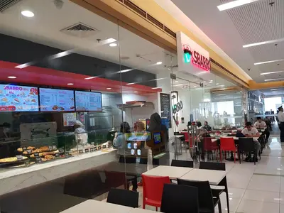 a fast food restaurant with people sitting at tables at Stay Amare Green La Salle Taft in Manila