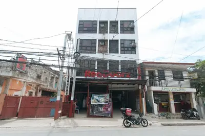 a motorcycle parked in front of a building at RedDoorz at DBuilders Rooms Lower Bicutan in Manila