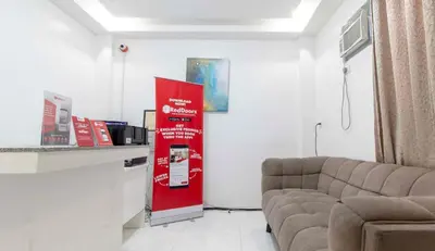 a waiting room with a red machine and a couch at RedDoorz at DBuilders Rooms Lower Bicutan in Manila