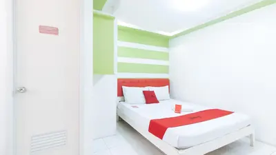 a white room with a bed with red accents at RedDoorz at DBuilders Rooms Lower Bicutan in Manila