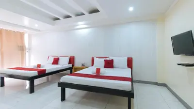 two beds in a room with a tv on the wall at RedDoorz at DBuilders Rooms Lower Bicutan in Manila