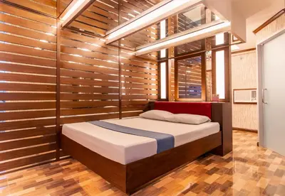 a bedroom with a bed in a room with wooden walls at Hotel Ava Gil Puyat in Manila