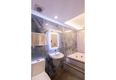a bathroom with a sink and a toilet and a mirror at Hotel Ava Gil Puyat in Manila