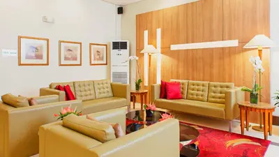 a living room with yellow couches and red pillows at One Pacific Place Serviced Residences in Manila