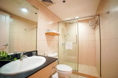 a bathroom with a sink and a shower and a toilet at One Pacific Place Serviced Residences in Manila