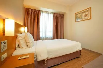 a hotel room with a bed and a window at One Pacific Place Serviced Residences in Manila