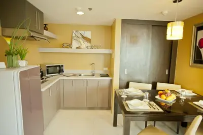 a small kitchen with a table and a dining room at The Exchange Regency Residence Hotel Managed by HII in Manila