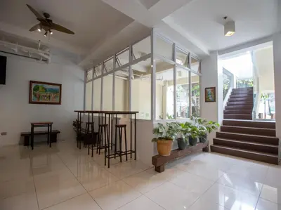 a living room with a staircase and some plants at Sulit Budget Hotel VMapa in Manila