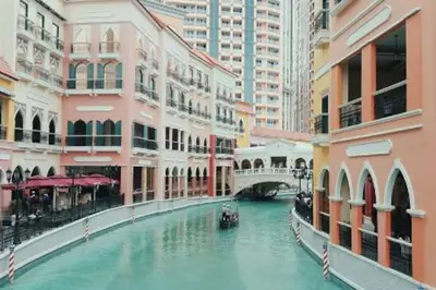 a canal with a boat in a city with buildings at Condotel Type in Manila