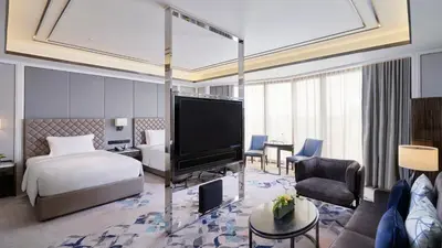 a hotel room with a bed and a flat screen tv at Hotel Okura Manila at Newport World Resorts in Manila