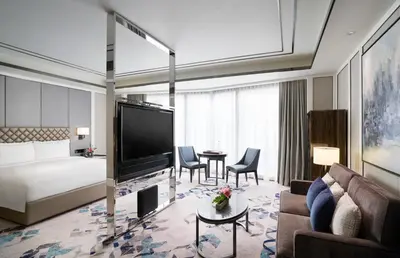 a hotel room with a bed and a living room at Hotel Okura Manila at Newport World Resorts in Manila