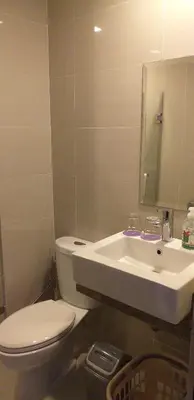 a bathroom with a white toilet and a sink at Eighty One Newport Boulevard in Manila