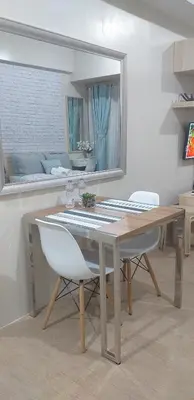 a dining room table with a white chair and a mirror at Eighty One Newport Boulevard in Manila