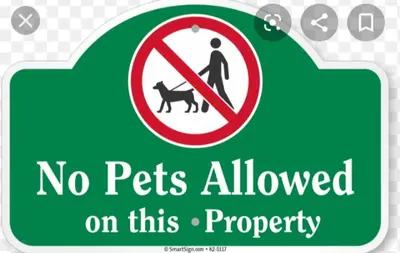 a green sign with a no pets allowed on this property at Palm Tree Villas 2 in Manila