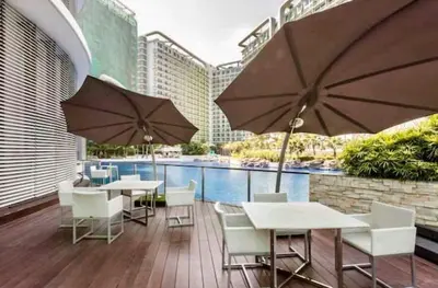 a patio with tables and chairs and umbrellas at Adam'sCrib Apartment 2BR by Azure Residences Near Manila International Airport in Manila