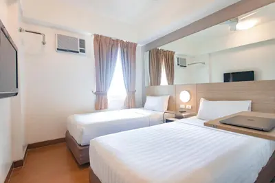 a hotel room with two beds and a window at Red Planet Makati Avenue Manila in Manila