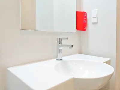 a bathroom with a white sink and a red phone at Red Planet Makati Avenue Manila in Manila