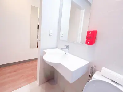 a white bathroom with a sink and a toilet at Red Planet Makati Avenue Manila in Manila
