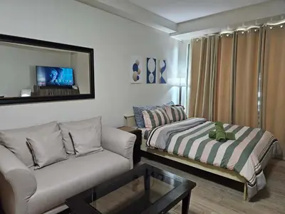 a living room with a bed and a couch at N place at Soho Central in Manila