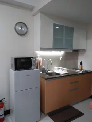 a small kitchen with a sink and a microwave at 101 Newport Boulevard C1 in Manila