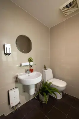 a white bathroom with a sink and a toilet at KL Tower Makati Apartments by PH Staycation in Manila