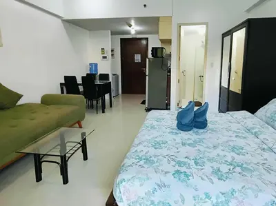 a bedroom with a bed and a couch and a table at Two Palm Tree Villas close to Manila Airport - Terminal 3 in Manila