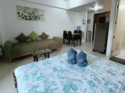 a room with a bed and a couch and a table at Two Palm Tree Villas close to Manila Airport - Terminal 3 in Manila