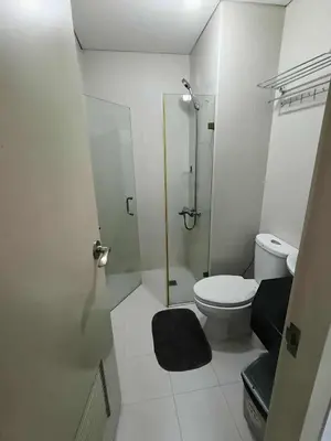 a small bathroom with a toilet and a shower at Two Palm Tree Villas close to Manila Airport - Terminal 3 in Manila