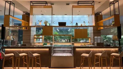 a kitchen with a bar with stools in front at Holiday Inn Express Manila Newport City by IHG in Manila