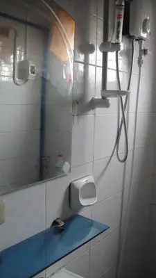 a bathroom with a shower with a sink and a mirror at JCP Room Rentals in Manila