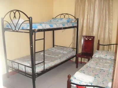 a bedroom with two bunk beds and a chair at JCP Room Rentals in Manila