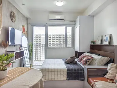 a bedroom with a bed and a large window at Studio Condo Manila by the Bay Roxas Blvd near US Embassy in Manila