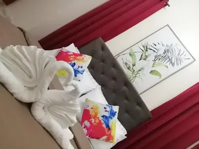 a bed with two pillows and a swan on it at H&M One Palmtree Villas in Manila