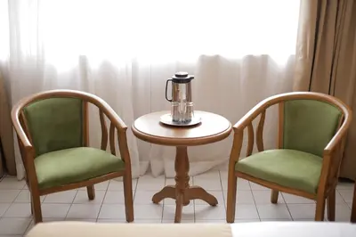 two chairs and a table with a tea kettle on it at Hotel Soriente in Manila