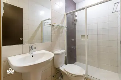 a bathroom with a toilet and a sink and a shower at Lorenzzo Suites Hotel Makati in Manila