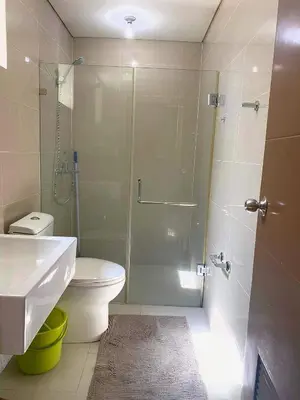 a bathroom with a shower and a toilet and a sink at The Palm Tree Condotel Manila Airport in Manila