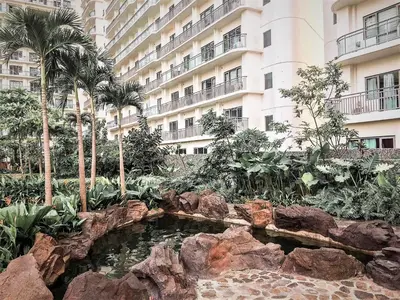 a hotel with a pond in front of a building at ACQUA Private Residences 1BR Condo in the heart of downtown Makati & Mandaluyong in Manila