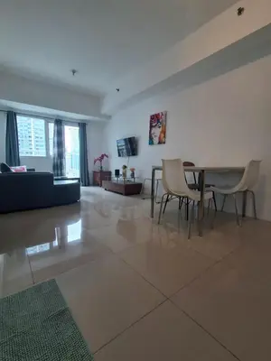 a living room with a table and chairs and a couch at Spacious 2BR in Jazz Residences Makati in Manila