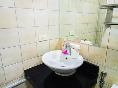 a bathroom with a white sink and a mirror at Forbes Area BGC Taguig Manila in Manila