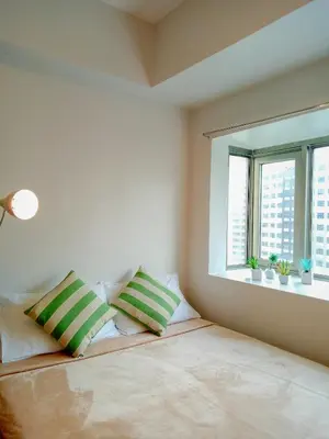 a bedroom with a bed with two pillows and two windows at Forbes Area BGC Taguig Manila in Manila