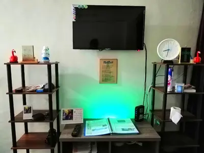 a flat screen tv hanging on a wall with a table at Condo Near NAIA Airport T 1,2,3&4 v4 in Manila