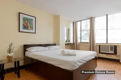 a bedroom with a large bed and a window at Victoria Mansions in Manila