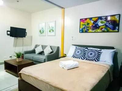 a hotel room with a bed and a couch at Uptown Mall Area Fort Bonifacio Manila in Manila