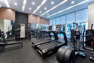 a gym with treadmills and cardio equipment in a building at The Sphere Serviced Residences Managed by HII in Manila