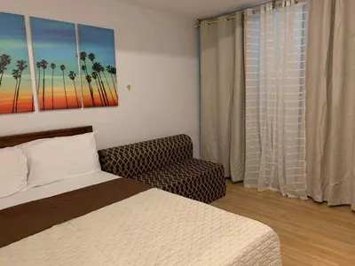 a bedroom with a bed and a couch and a window at AZURE C5 MAN-MADE BEACH BALCONY Multiple Units in Manila