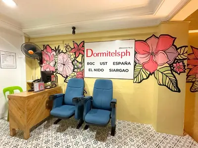 a waiting room with three chairs and a sign on the wall at Dormitelsph UST in Manila
